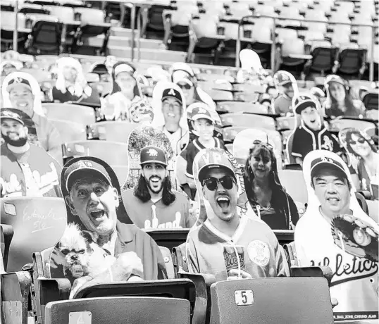  ?? KYLE SKINNER/AP ?? Cutouts of Athletics fans are displayed at RingCentra­l Coliseum in Oakland. In lieu of attending games during the pandemic, fans can pay to have cutouts of themselves at the park.