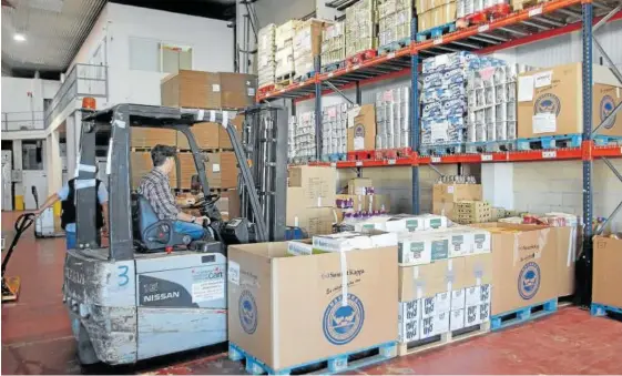  ??  ?? Un voluntario, en la despensa del Banco de Alimentos en el Polígono Plazaola de Berrioplan­o.