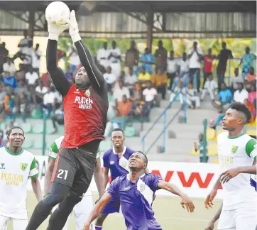  ??  ?? Goalkeeper Dalandi Isah of Plateau United goes for an aerial ball while teammates and MFM players wait for a slip during their league match