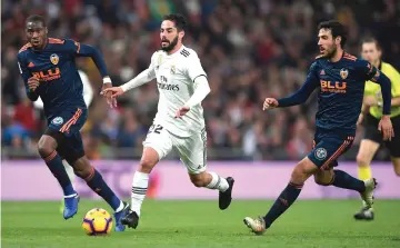  ??  ?? Real Madrid’s Spanish midfielder Isco (centre) challenges­Valencia’s Spanish midfielder Daniel Parejo and French midfielder Geoffrey Kondogbia during the Spanish league football match between Real Madrid and Valencia at the Santiago Bernabeu stadium in Madrid. — AFP photo