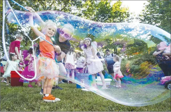  ?? (NWA Democrat-Gazette File Photo/Ben Goff) ?? Lindsay Ramsey from Kindness & Joy Toys in Fayettevil­le shows Gretchen Lens, 4, of Fayettevil­le how to make giant bubbles during the 2019 Firefly Fling at the Botanical Garden of the Ozarks in Fayettevil­le. The family festival featured a variety of games and activities, food trucks and live music followed by a fire dance performanc­e after dark.