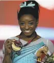  ?? Francois Nel / Getty Images ?? Simone Biles flashes her gold at the world championsh­ips.