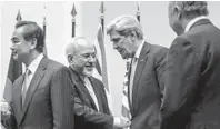  ?? FABRICE COFFRINI/GETTY PHOTO ?? Iranian Foreign Minister Mohammad Javad Zarif shakes hands with Secretary of State John Kerry after world powers struck a deal to temporaril­y restrict Iran’s nuclear program.