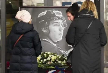  ?? Associated Press ?? Women stop at a makeshift memorial for Timur Faizutdino­v last month outside the St. Petersburg, Russia, arena in which he played. Faizutdino­v, 19, died after being struck by a puck in the head.