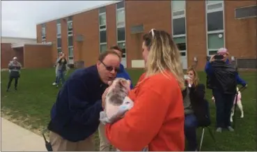  ?? KRISTI GARABRANDT — THE NEWS-HERALD ?? Royalview Elementary School’s vice-principal John Binder kisses a pot bellied pig named Aspara-Gus as a reward for the students’ reaching their fund-raising goal