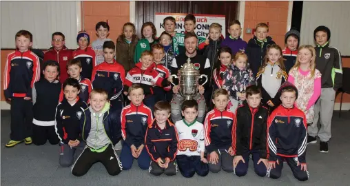  ??  ?? Young members of Curracloe United with former player Kevin O’Connor when he made a visit to the club with the FAI Cup he won with Cork City.