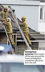  ??  ?? Emergency services Police closed off the area around the home as firefighte­rs coaxed the girls down from the roof