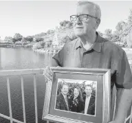  ?? ORANGE COUNTY REGISTER VIA AP ?? Frank Kerrigan holds a photo of his three children, John, Carole and Frank, near Wildomar, California. Kerrigan was told Frank had died.