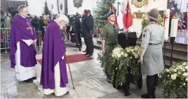  ?? WOJTEK STROZYK AP ?? Catholic priests bowing with respect before the urn with ashes of slain Gdansk city Mayor Pawel Adamowicz at the start of his funeral Mass on Saturday.