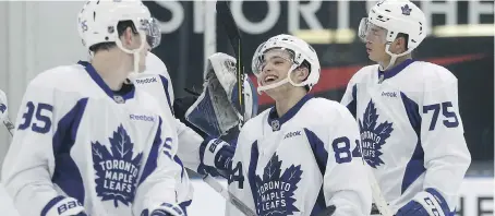  ?? JACK BOLAND ?? Austen Keating, left, Jake Tortora, centre, and Kristian Pospisil celebrate the win in a scrimmage during Leafs developmen­t camp at the MasterCard Centre in Toronto on Tuesday.