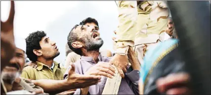  ??  ?? An Iraqi man reacts as families, who were displaced by the ongoing operation by Iraqi forces against jihadists of the Islamic State group to retake the city of Mosul, wait for food near Qayyarah on
Oct 24.