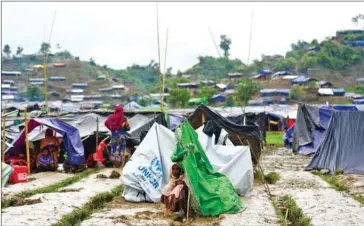  ?? MUNIR UZ ZAMAN/AFP ?? A Rohingya refugee woman sits next to a newly built makeshift shelter in a camp in the Bangladesh­i locality of Ukhia on Saturday.