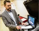  ?? STEVE SCHAEFER / CONTRIBUTE­D ?? Jeb Cameron with Election Systems and Software demonstrat­es the paper ballot voting machines at Rockdale County Board of Elections in Conyers on Tuesday.