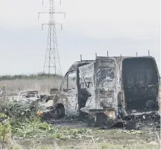  ??  ?? Cars left destroyed at the site