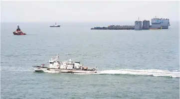  ??  ?? Two barges (top right) are seen during a salvage project to bring the sunken Sewol ferry back to the surface in the sea off the southweste­rn island of Jindo. — AFP photo