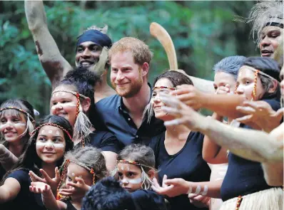  ??  ?? Prince Harry poses for a photo with Butchulla members during a ceremony on Fraser Island, Australia, on Monday.