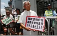  ?? (AP/Kin Cheung) ?? Hong Kong’s outspoken cardinal Joseph Zen (center) and other religious protesters hold placards with “Respects religious freedom” written on them during a demonstrat­ion on July 11, 2012, outside the China Liaison Office in Hong Kong.