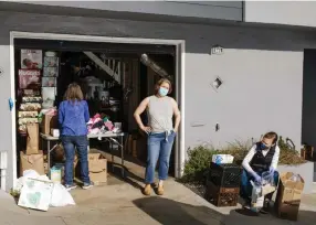  ??  ?? Misa Perron-burdick, center, organizes a supplies bank in her garage, with help from her neighbors, Lisa Leighton, left, and Natalie Mead.