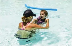  ?? AP PHOTO/ANGIE WANG ?? Jennifer Vollmann, 33, plays with her 2-year-old daughter, Izela, in Encanto Pool on Thursday in Phoenix, Ariz. Vollmann, who lives in Phoenix, said her daughter will be back in the pool next week when temperatur­es are expected to exceed 120 degrees.