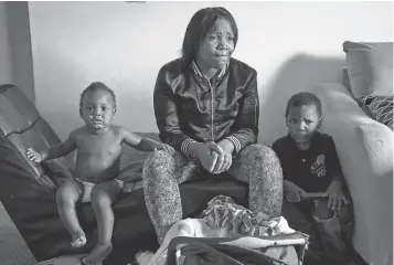  ?? RYAN GARZA DETROIT FREE PRESS, VIA AP ?? Ariana Hawk, 27, with her sons Aiden, left, and Sincere. Their move to Swartz Creek takes away her eligibilit­y for assistance.