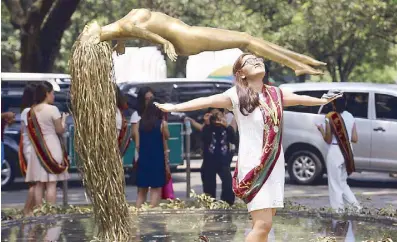  ?? MICHAEL VARCAS ?? A graduate poses beside the ‘Uplift’ sculpture made by artist Ferdinand Cacnio at UP Diliman yesterday.