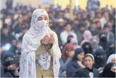  ?? AFP ?? A Pakistani woman prays last week for the victims of the Taliban assault on a school in Peshawar on Dec 16 last year.