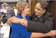  ?? Arkansas Democrat- Gazette/ BENJAMIN KRAIN ?? Valerie Tatum ( right), founder and superinten­dent of the Covenant Keepers charter school, hugs Ouida Newton as she thanks Newton and other members of the Arkansas Board of Education for their vote keeping the school in operation.