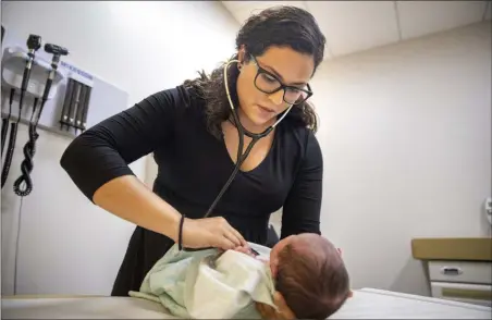  ?? AMR ALFIKY — THE ASSOCIATED PRESS ?? Dr. Jasmine Saavedra, a pediatrici­an at Esperanza Health Centers whose parents emigrated from Mexico in the 1980s, examines Alondra Marquez, a newborn baby, in her clinic in Chicago on Tuesday.