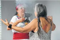  ?? Jerry Lara / Staff photograph­er ?? Maria Tlayolotzi­n, left, performs a spiritual cleansing ritual on Graciela Gonzalez at a SanArte health clinic in Guadalupe Plaza.