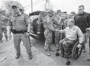  ?? Julio Cortez / Associated Press file photo ?? Gov. Greg Abbott greets a National Guard member on Sept. 21 after a news conference along the Rio Grande in Del Rio. Abbott has come under fire as the state struggles to pay the soldiers.