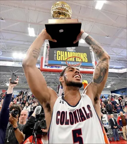  ?? Matt Freed/Post-Gazette ?? Robert Morris’ A.J. Bramah hoists the Northeast Conference championsh­ip trophy Tuesday night after the Colonials defeted Saint Francis, 77-67, at UPMC Events Center.