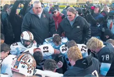  ?? | JESSICA KOSCIELNIA­K/SUN-TIMES ?? Washington and Sacred Heart-Griffin players pray postgame with coaches Darrell Crouch (left) and Ken Leonard.