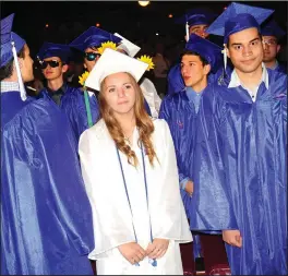  ??  ?? Above, Cumberland graduate Hailey Ballou takes her seat with members of the Class of 2018 during Cumberland High School’s 124th Commenceme­nt. At right, CHS Salutatori­an Caroline Squizzero and Valedictor­ian Dev Ramesh enjoy a laugh onstage of the Providence Performing Arts Center.