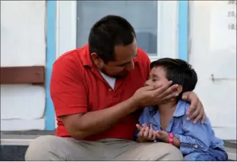  ?? LOREN ELLIOTT / REUTERS ?? Walter Armando Jimenez Melendez, an asylum seeker from El Salvador, arrives with his four-year-old son Jeremy at La Posada Providenci­a shelter in San Benito, Texas on Tuesday.