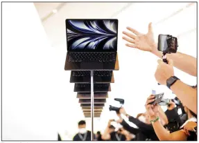  ?? (AP Photo/Noah Berger) ?? The new Apple MacBook Air with the M2 processor is displayed as visitors take photos of it, following the keynote presentati­on of Apple’s World Wide Developer Conference on the campus of Apple’s headquarte­rs in Cupertino, Calif., last month.