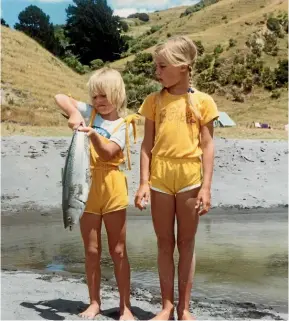  ??  ?? Bobbie McKay, right, watches her sister Beth struggle to hold her recently caught fish during their summer break in Ruato¯ ria.