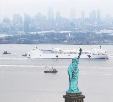  ?? MIKE SEGAR/REUTERS ?? The navy hospital ship USNS Comfort passes the Statue of Liberty as it enters New York Harbor on Monday. The ship’s
1,000 beds will provide an alternate treatment site for non-coronaviru­s patients in the pandemic-wracked city.