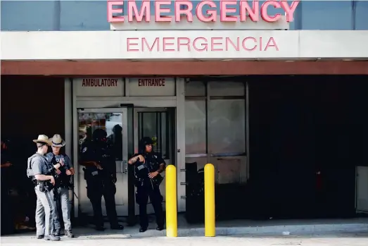  ?? PHOTO AFP ?? Des policiers new-yorkais montent la garde à l’entrée de la salle des urgences du Lebanon Hospital où s’est déroulé le drame.