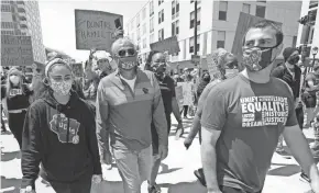  ?? MIKE DE SISTI / MILWAUKEE JOURNAL SENTINEL ?? Milwaukee Bucks owner Marc Lasry, center, and his son, Milwaukee Bucks Senior Vice President Alex Lasry, march down East Juneau Avenue in Milwaukee in early June in support of social justice.