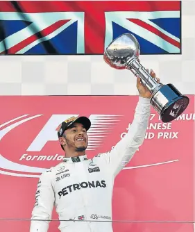  ?? Picture: AFP/ KAZUHIRO NOGI ?? SITTING PRETTY: Lewis Hamilton holds up his winner’s trophy