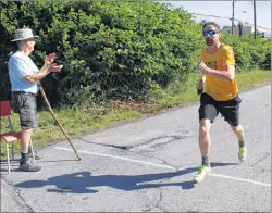  ?? CHRIS SHANNON/CAPE BRETON POST ?? Jason McGuigan of Sydney was the first to cross the finish line as Brian Young looked on, welcoming the runners as they finished. Young and his wife Nancy were on hand as the fun run was renamed in honour of their daughter, Carmen Young, who died following a double lung transplant in 1992.