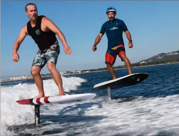  ?? (Photos Laurent Martinat) ?? Charles Deleau, champion du monde de kitesurf (à gauche en surf foil tracté) et Fabien Feutrier (à droite sur un surf foil électrique) sur le plan d’eau hyérois.