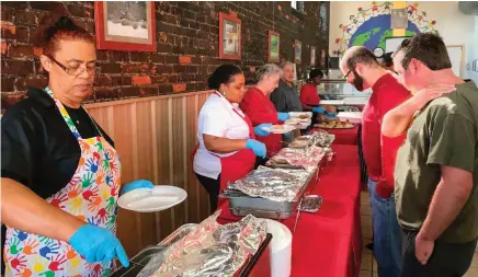  ??  ?? Lisa Thomas-McMillan (left) and volunteers serve up home-style fare in a cheery spot four days a week.