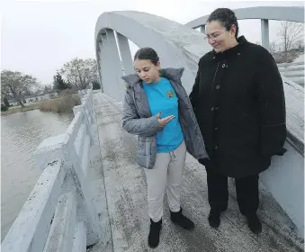  ?? TYLER BROWNBRIDG­E/WINDSOR STAR ?? Sarah-Rose Davis, left, and her mother, Rosemary Davis, return to the scene of their spectacula­r crash on the River Canard bridge on Tuesday. “I thought I was dreaming,” said Sarah-Rose, when asked about Sunday’s terrifying crash.