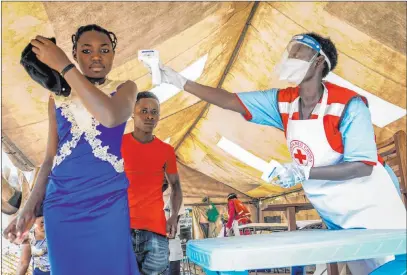  ?? Ronald Kabuubi The Associated Press ?? People coming from Congo have their temperatur­es measured to screen for symptoms of Ebola at the Mpondwe border crossing with Congo in western Uganda on Friday.