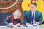  ?? EDDIE MOORE/JOURNAL ?? Gov. Michelle Lujan Grisham, with Lt. Gov. Howie Morales in the Governor’s Office in Santa Fe, signs an executive order to end PARCC testing Jan. 3.
