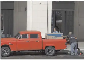  ?? (AP/Ismael Francisco) ?? Men load a new refrigerat­or into a pickup in Havana earlier this week. In recent months, Cuban authoritie­s have started to promote websites that allow people to pay in U.S. dollars through a credit card for some items.