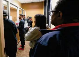  ?? CURTIS COMPTON / CCOMPTON@AJC.COM ?? Dominique Bowen (second from left) and Victor Smith (right) are among the voters who lined up at the Fulton County elections office in Atlanta on Friday to make sure their vote is counted.