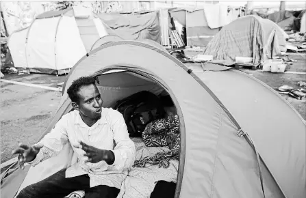  ?? ALESSANDRA TARANTINO THE ASSOCIATED PRESS ?? An asylum seeker from the Horn of Africa, who did not want to be identified by his name, sits in a camp on the outskirts of Rome. .
