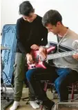  ??  ?? Nino Stübinger erklärt dem zwölfjähri­gen Erdem Tas seinen E-Bass.